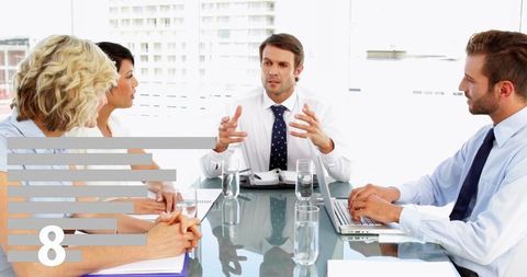 Business Manager Leading Strategy Meeting at Glass Conference Table with Laptop and Team