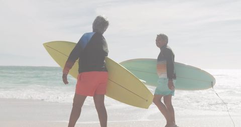 Senior Couple Strolling with Surfboards on Beach - Download Free Stock Images Pikwizard.com
