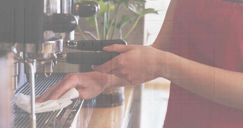 Barista wiping espresso machine holding portafilter in sunlit minimalist coffeehouse