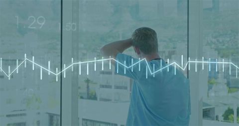 Medical professional standing at hospital window gazing at city with ecg waveform overlay