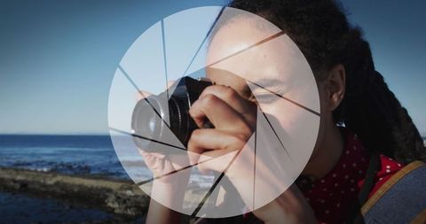 Photographer by ocean with camera lens overlay