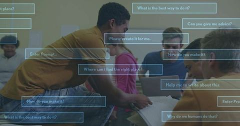 Male student leaning over papers pointing as peers collaborate using laptops and ai prompts