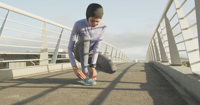 Muslim Woman Tying Running Shoes on Sport Footbridge - Download Free Stock Images Pikwizard.com