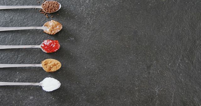 Spoons with Various Food Ingredients Arranged on Black Slate Background - Download Free Stock Images Pikwizard.com