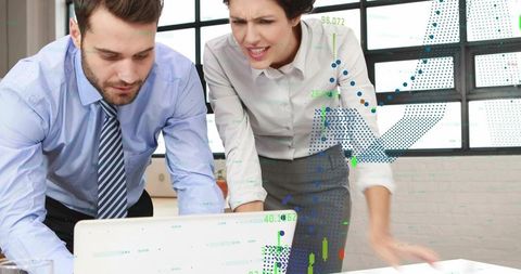 Leaning coworkers analyzing financial dashboard on laptop while collaborating on strategy