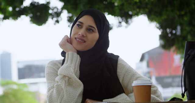 Muslim woman enjoying outdoor coffee at park - Download Free Stock Images Pikwizard.com