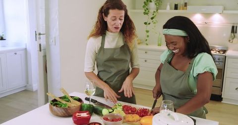 Two Women Enjoying Cooking Together in Modern Kitchen