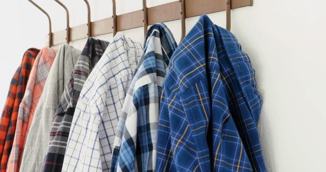 Row of Plaid Shirts Hanging on Wooden Hooks - Download Free Stock Images Pikwizard.com