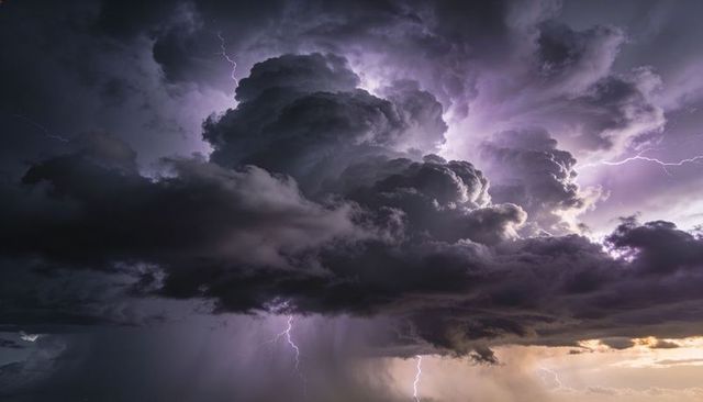 Towering Cumulonimbus with Forked Lightning over Golden Horizon and Rain Shafts at Twilight