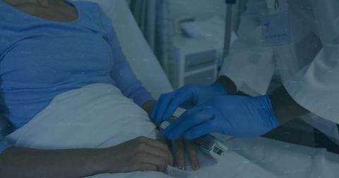 Clinician attending patient in hospital with pulse oximeter