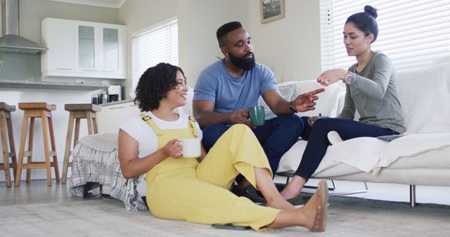Diverse male and female friends talking and having tea at home in slow motion. Friendship, leisure and lifestyle concept.