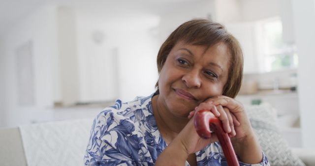 Elderly Woman Smiling and Relaxing Indoors with Walking Cane - Download Free Stock Images Pikwizard.com