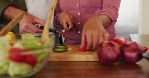 Couple Chopping Vegetables Together in Kitchen