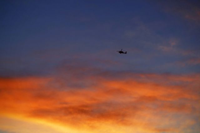 Helicopter flying against a vibrant sunset sky with hues of orange and blue creating a dramatic contrast. Perfect for use in travel advertisements, aviation businesses, scenic backgrounds, or inspirational posters showcasing freedom and adventure.