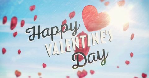 Happy valentine's day greeting with floating red hearts over sunlit blue sky