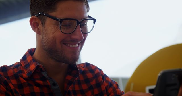 Smiling Man in Glasses Using Smartphone at Workplace - Download Free Stock Images Pikwizard.com