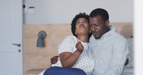 Joyful african american couple embracing positive pregnancy news