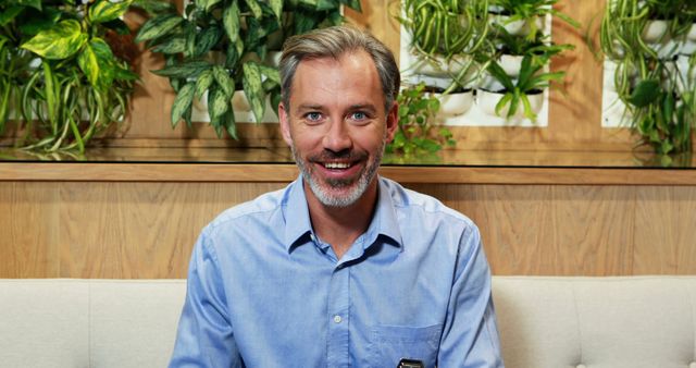 Man Smiling in Modern Office with Green Plants - Download Free Stock Images Pikwizard.com