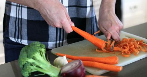 Hands peeling carrot home kitchen meal preparation