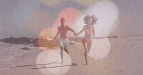 Joyful Couple Running on Beach During Vacation with Ocean Waves