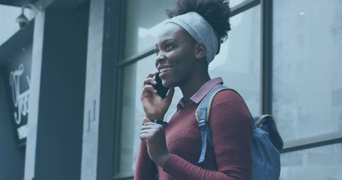 Smiling Woman Communicating on Smartphone in Cityscape