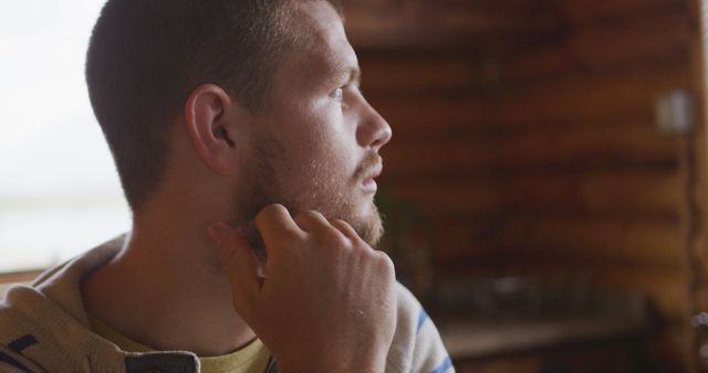 Bearded Man in Thoughtful Pose Inside Rustic Cabin - Download Free Stock Images Pikwizard.com