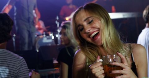 Joyful Woman Enjoying Concert Nightlife with Drink