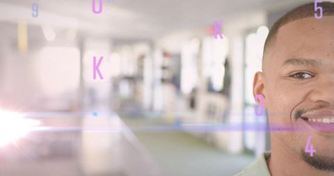 Smiling man wearing collared shirt standing in modern office corridor with purple overlays