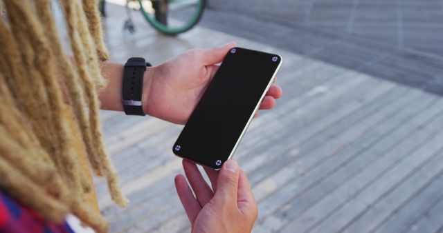 Person with Dreadlocks Holding Black Smartphone Outdoors - Download Free Stock Images Pikwizard.com