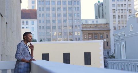 Pensive professional on urban balcony amidst morning calm