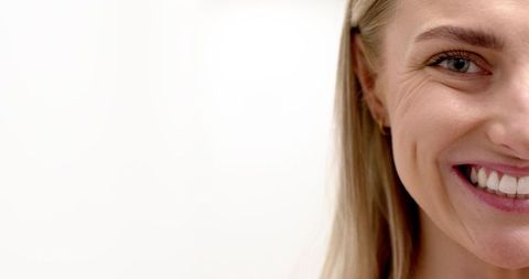 Closeup smiling blonde woman showing right side of face dimple bright teeth copy space