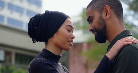 Interracial couple embracing in urban setting