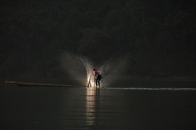 Fisherman working on tranquil lake at dawn - Download Free Stock Photos Pikwizard.com