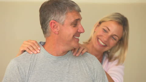 Woman Massaging Husband’s Shoulders Creating Relaxing Atmosphere at Home