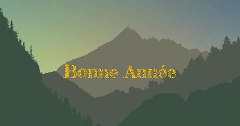 Golden bonne année lettering over layered mountain silhouettes at dawn