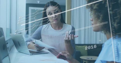 Professional Women Collaborating on Data Analysis in Modern Office