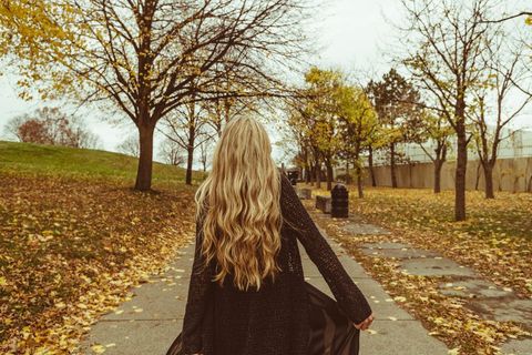 Woman with Long Hair Walking Through Autumn Park