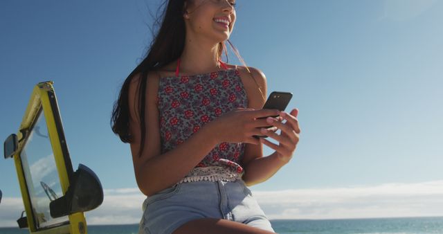 Happy caucasian woman sitting on beach buggy by the sea talking on smartphone - Download Free Stock Photos Pikwizard.com
