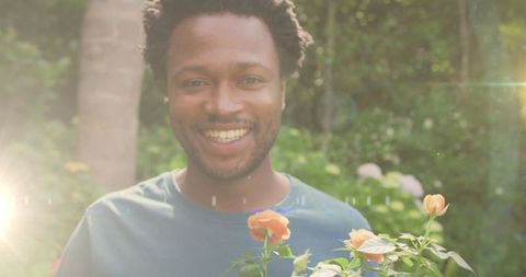 Man Enjoying Flowers in Sunlit Garden Environment