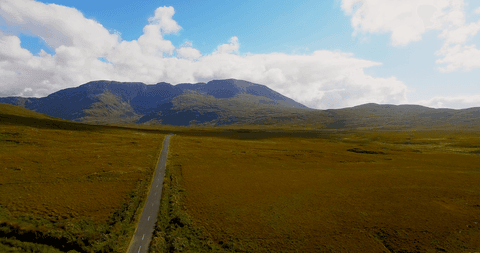 Transparent Open Road Through Lush Green Countryside With Mountains