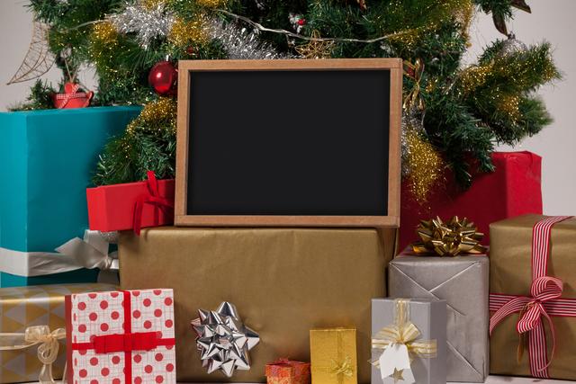 Blank slate with presents and christmas tree during christmas time