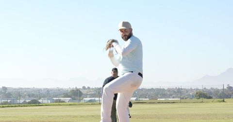 Right-handed Pitcher Delivering Windup on Suburban Baseball Field Under Clear Sky