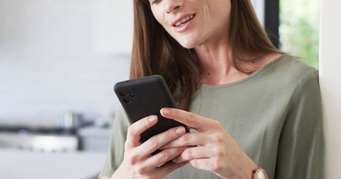 Middle-aged Woman Engages with Smartphone in Home Environment - Download Free Stock Images Pikwizard.com