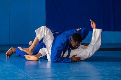Mixed martial artists training multi-position grappling techniques in dojo