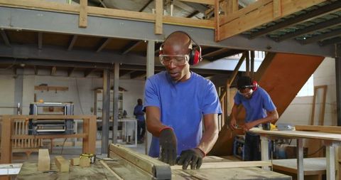 Skilled Carpenter Working with Table Saw in Modern Woodshop