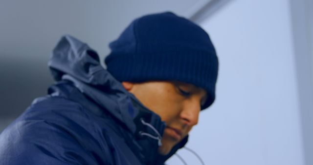 Man Wearing Blue Winter Jacket and Hat Focusing on Task - Download Free Stock Images Pikwizard.com