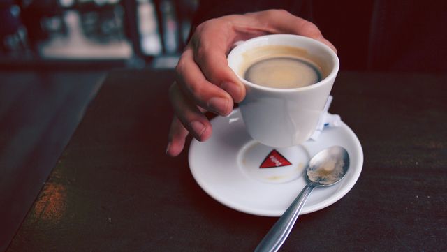 Close-Up of Hand Holding Espresso Cup in Cafe Setting - Download Free Stock Photos Pikwizard.com