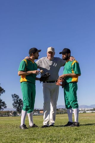 Coach draping arm around two baseball players teaching strategy with data overlay