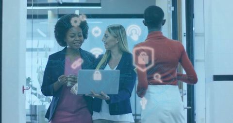 Diverse Businesswomen Collaborating with Technology in Office Hallway