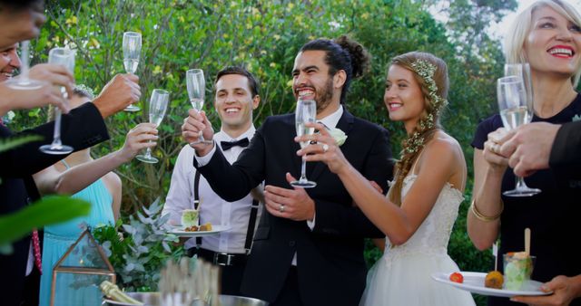 Joyful Wedding Celebration with Bride and Groom Toasting Outdoors - Download Free Stock Images Pikwizard.com